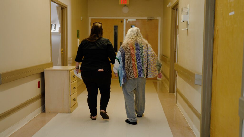 A woman is being assisted by a nurse at a respite care facility